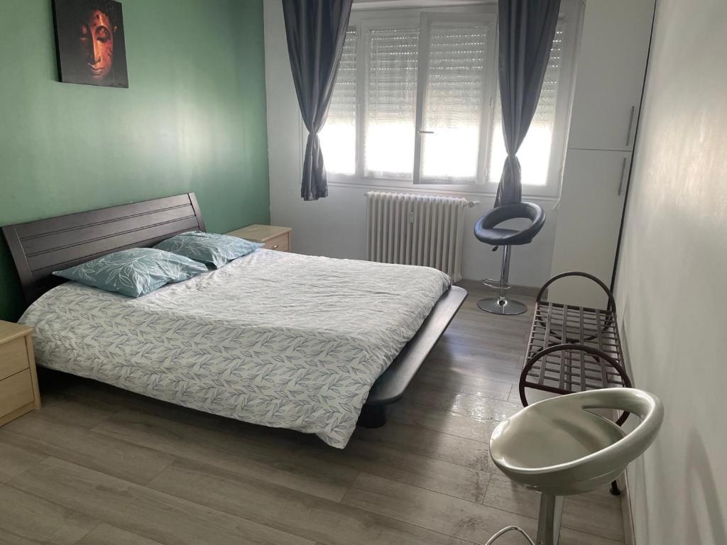 ein Schlafzimmer mit einem Bett, einem Stuhl und einem Fenster in der Unterkunft Nice appartement Avenue des Fleurs in Nizza