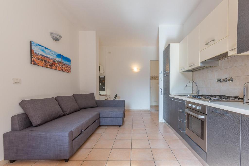 uma sala de estar com um sofá e uma cozinha em Porta Maggiore Apartment em Bolonha
