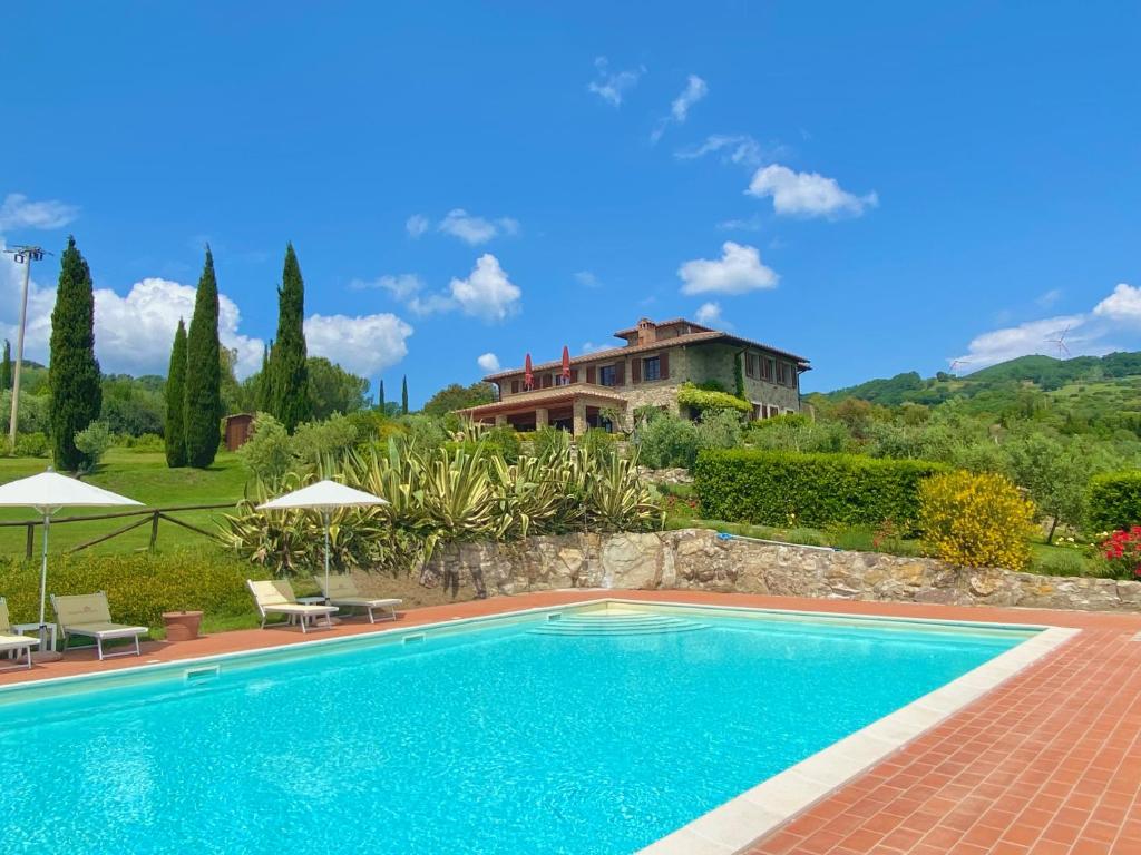 a swimming pool in front of a house at Relais Poggio Del Melograno in Montecatini Val di Cecina