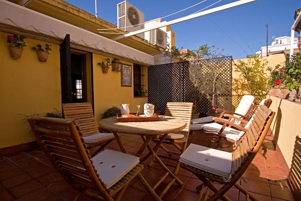 patio con mesa y sillas en el balcón en River House, en Sevilla