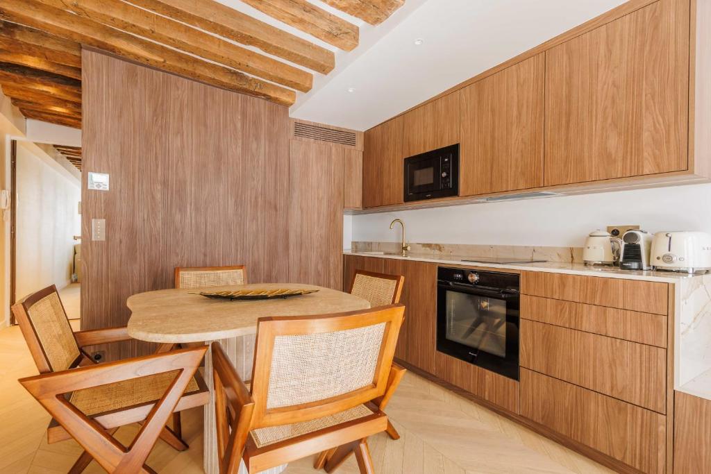 - une cuisine avec une table et des chaises dans la chambre dans l&#39;établissement Stunning Oasis near Louvre and Saint-Honoré - 1 Bedroom, à Paris