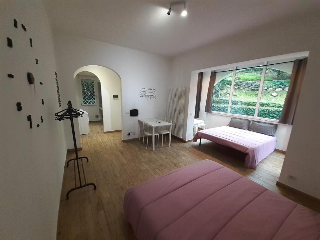 Schlafzimmer mit einem Bett, einem Schreibtisch und einem Fenster in der Unterkunft Le Colonne in Stresa