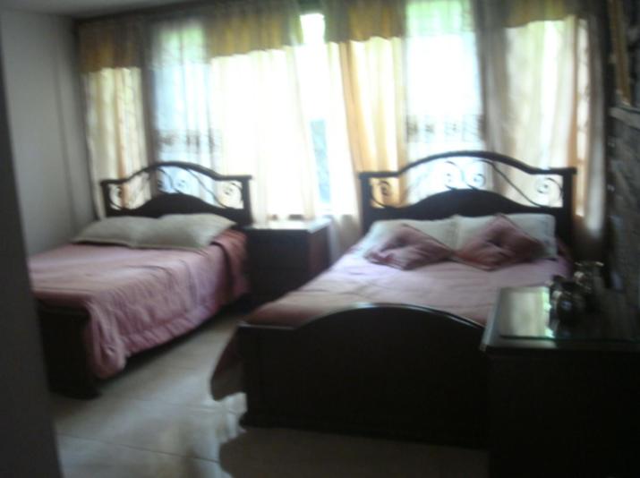 a bedroom with two beds with windows and a table at Medellín Kimball's Appartments! in Medellín