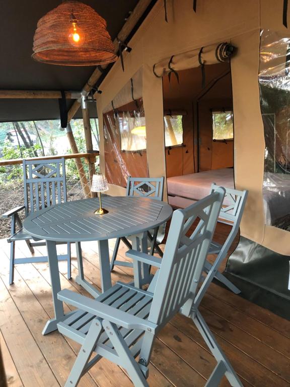 una mesa y sillas en el porche de una casa en AgriGlamping La Diaccia, en Serravalle Pistoiese