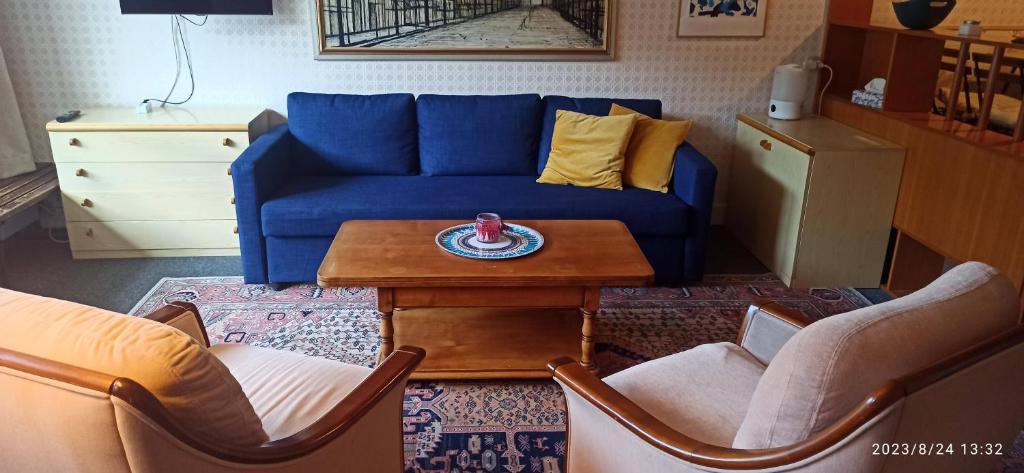 a living room with a blue couch and a table at La Valette in Isola
