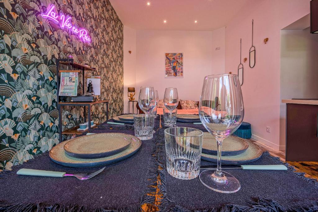 une table avec des assiettes et des verres à vin dessus dans l'établissement Maisonnette Haut de Gamme proche de Disneyland et de Paris, à Neufmontiers-lès-Meaux