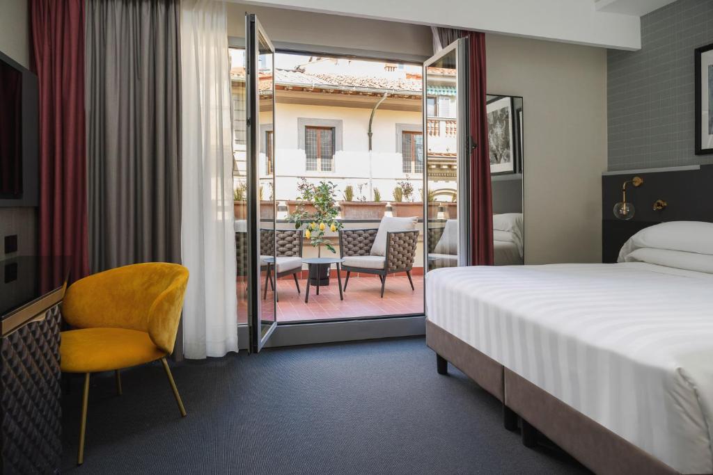 um quarto de hotel com uma cama e uma varanda em iQ Hotel Firenze em Florença