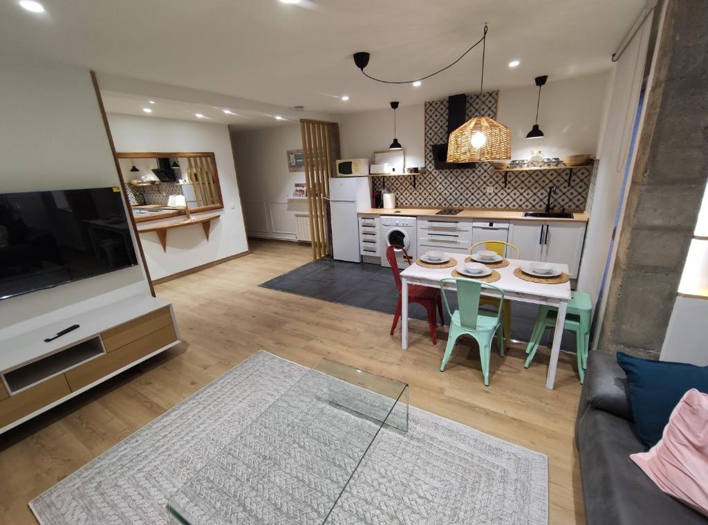 Lindo pisito في ليون: مطبخ وغرفة معيشة مع طاولة وكراسي