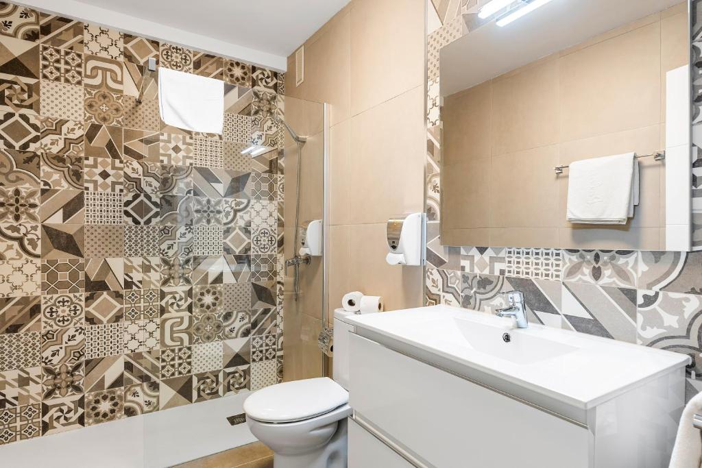 a bathroom with a toilet and a sink at Paloma Beach Apartments in Los Cristianos