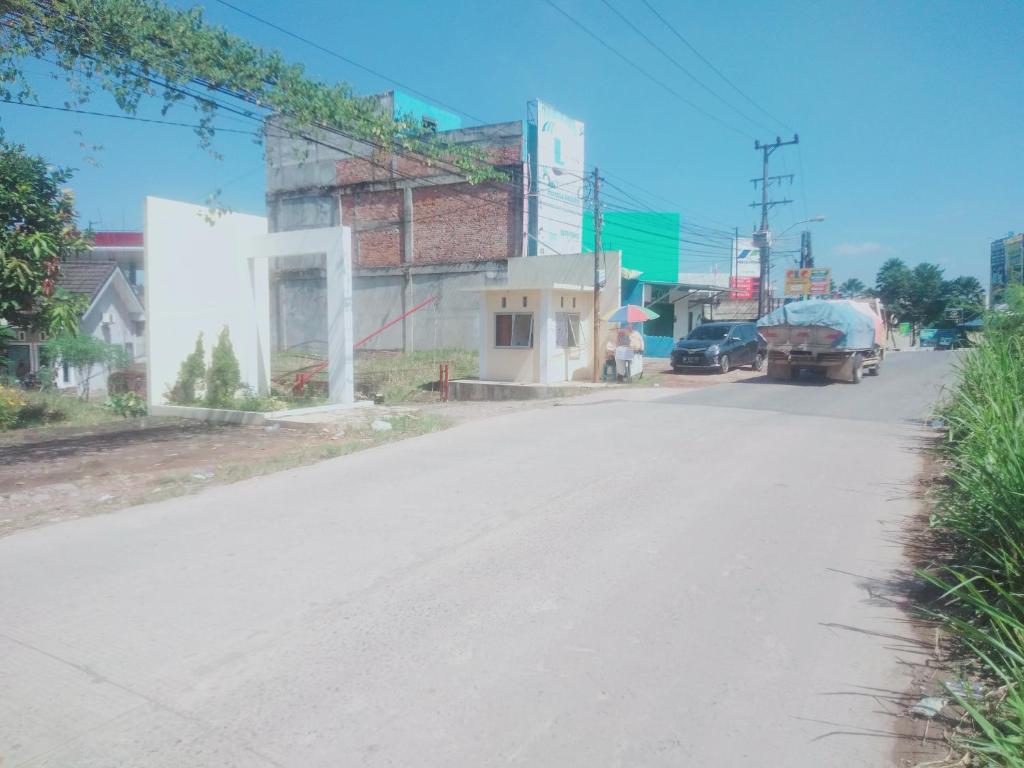 an empty street with a car parked on the side of the road at D'House Homestay in Palembang