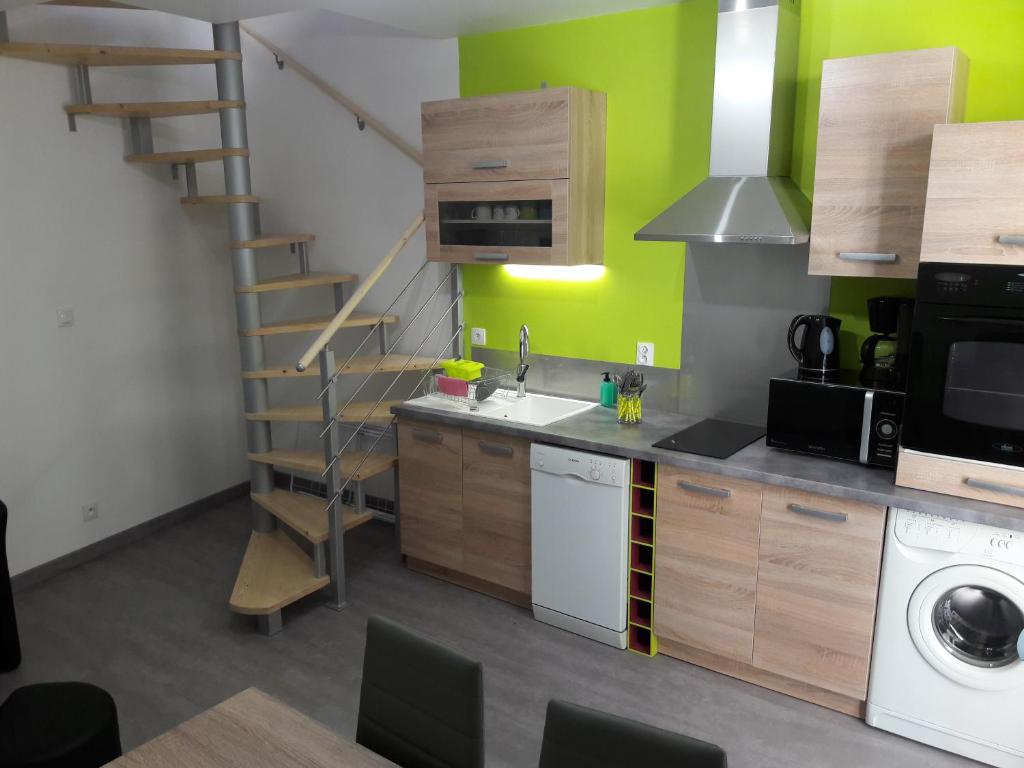 una cucina con lavandino e una scala con pareti verdi di appartement tranquille a Rochechouart