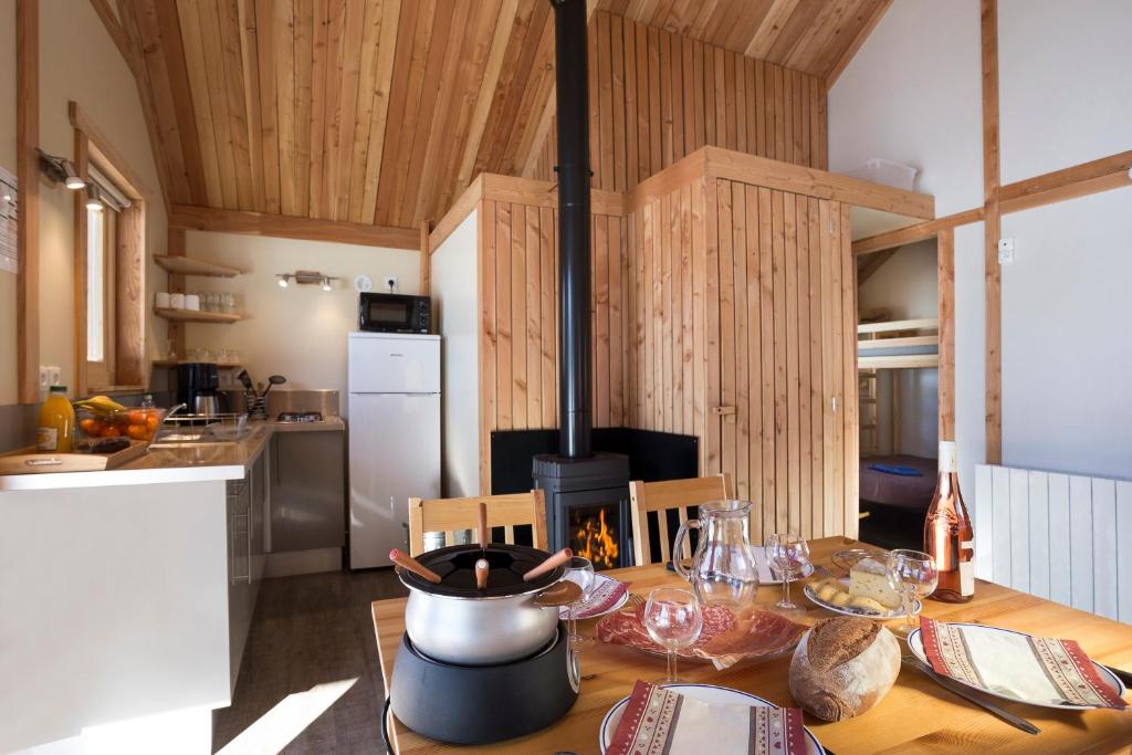een keuken met een houten tafel en een fornuis bij Huttopia Vallouise in Vallouise