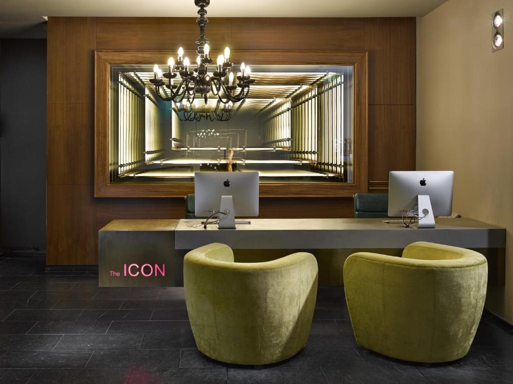 hol ze stołem, 2 krzesłami i lustrem w obiekcie The ICON Hotel & Lounge w Pradze