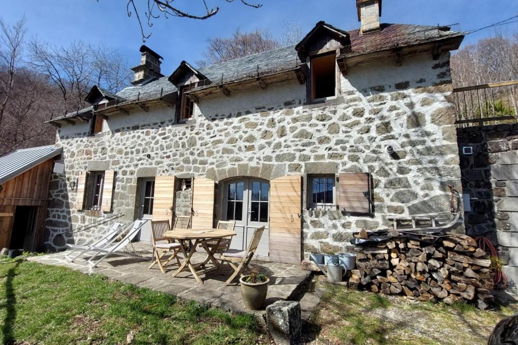 a stone house with a picnic table in front of it at Le Bois Haut in Saint-Jacques-des-Blats