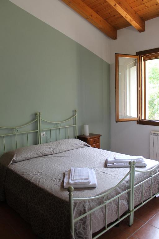 Un dormitorio con una cama verde y una bandeja. en La Rizza, en Bentivoglio