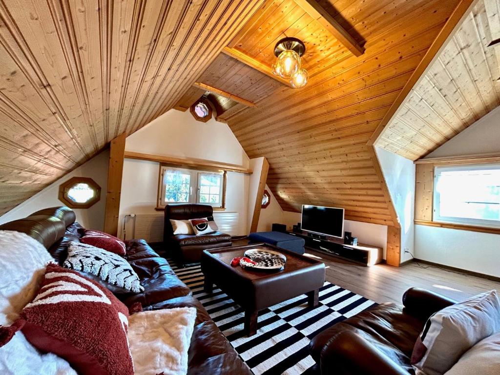 ein Wohnzimmer mit einem Sofa und einem Tisch in der Unterkunft Wunderschöne Maisonette-Ferienwohnung in stattlichem Toggenburgerhaus in Sankt Peterzell