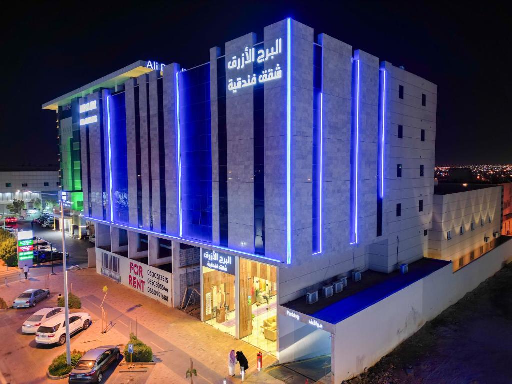 un edificio con luces azules por la noche en البرج الازرق شقق فندقية Alburj Alazraq, en Riad