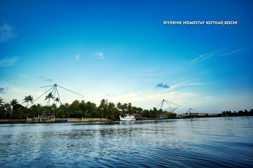 a boat on a river with windmills in the background at Riverine Homestay Kochin in Ernakulam