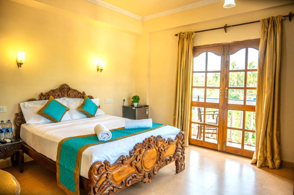 a bedroom with a bed and a large window at Casa Eternal Boutique Hotel - Calangute in Calangute