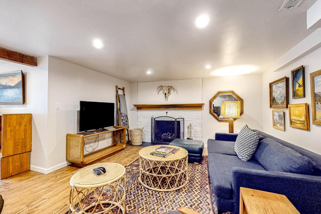 波特蘭的住宿－Taylors Ferry Retreat，客厅配有蓝色的沙发和电视