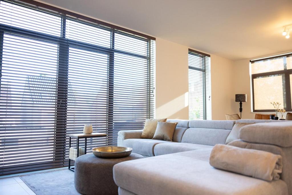 un soggiorno con divano e una grande finestra di Brand New Apartment Sint-niklaas a Sint-Niklaas