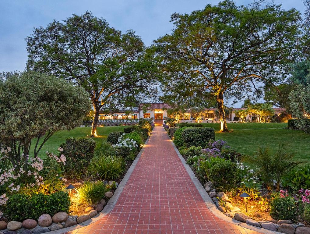 ランチョ・サンタ・フェにあるThe Inn at Rancho Santa Feの木々や花の咲く庭園の煉瓦道