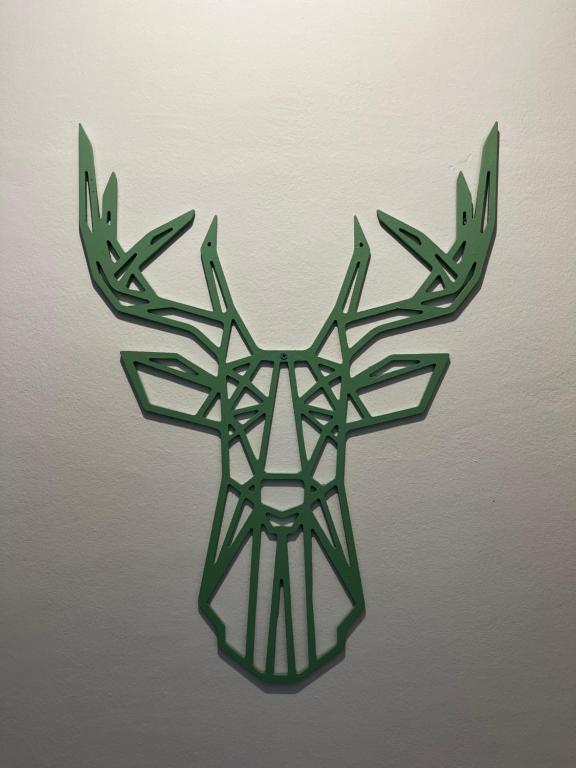 a green reindeer head ornament on a wall at Appartement Vue de Mer Pied dans l'eau in Gabès