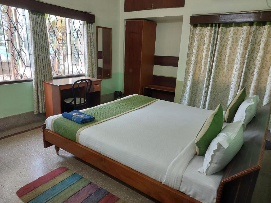a bedroom with a large bed and two windows at Riverview Guest House in Guwahati