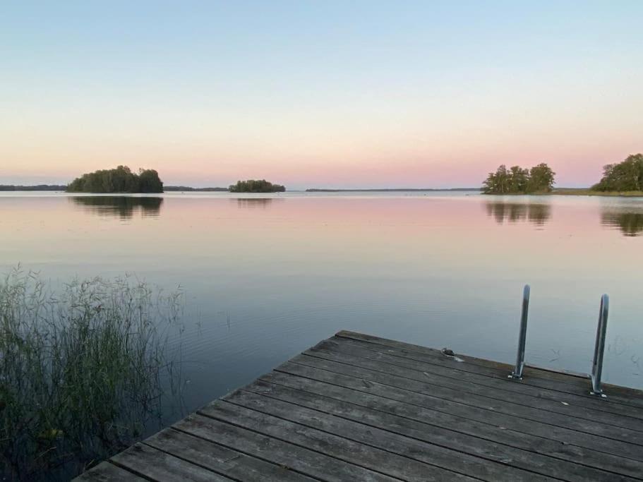 a view of a lake with a wooden dock at Spacious house near water and nature in Odensbacken