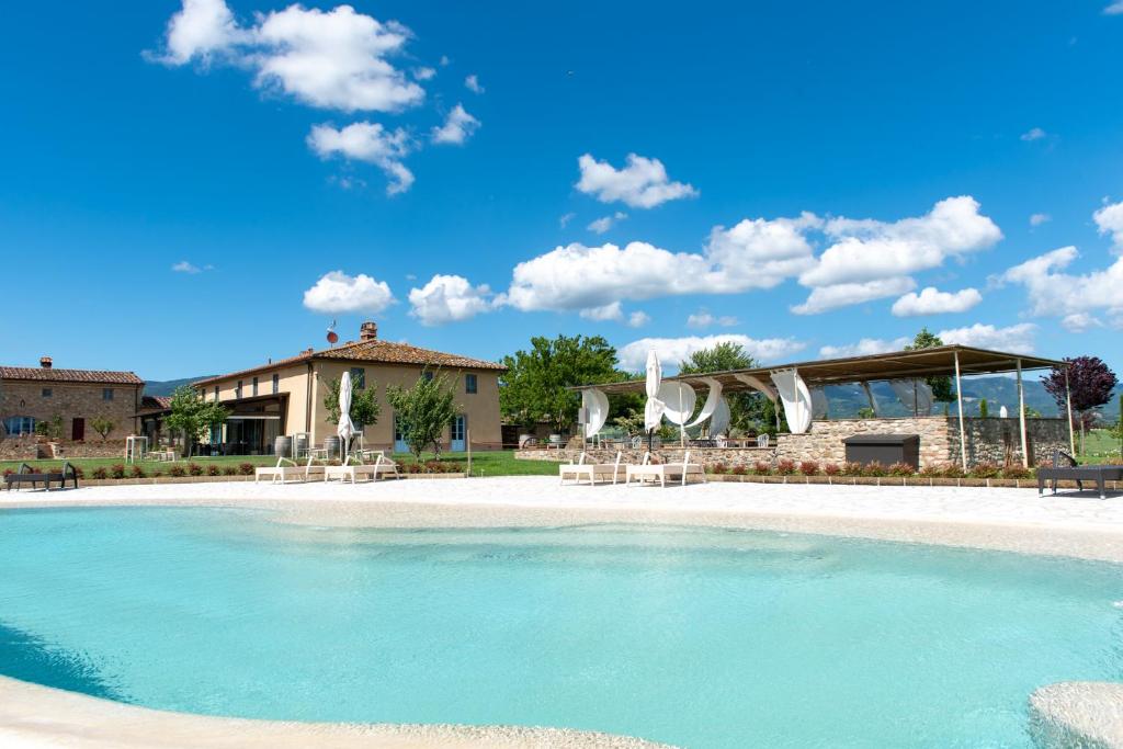um resort com piscina em frente a um edifício em Tenuta Le Tre Virtù em Scarperia