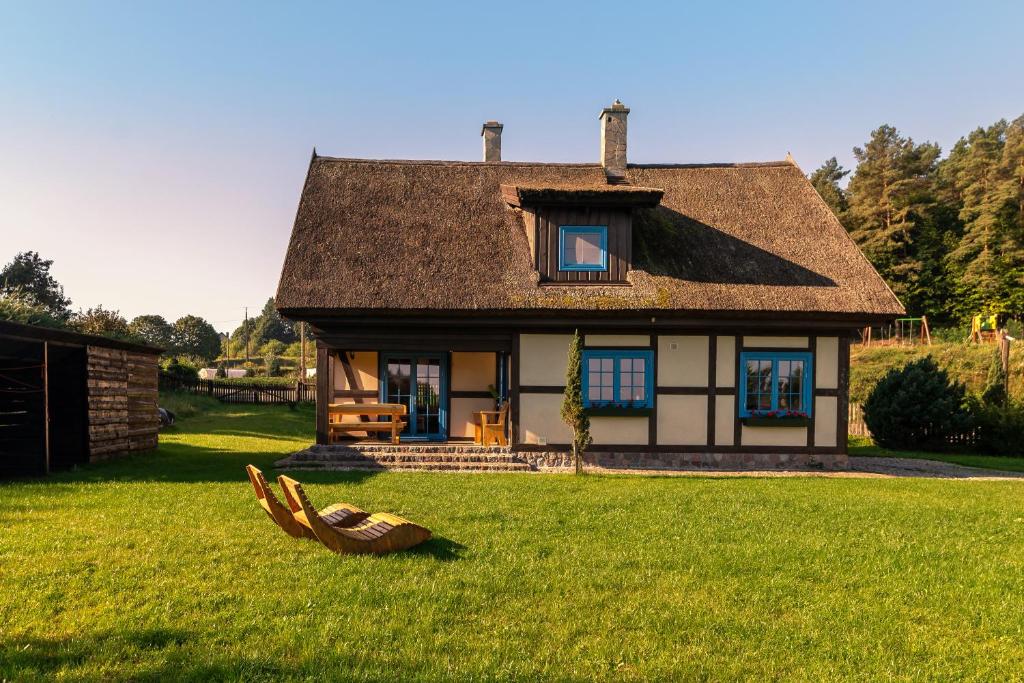mały domek w trawie z przodu w obiekcie Kaszuby, dom kaszubski nad jeziorem Danielowa Dolina w mieście Szymbark