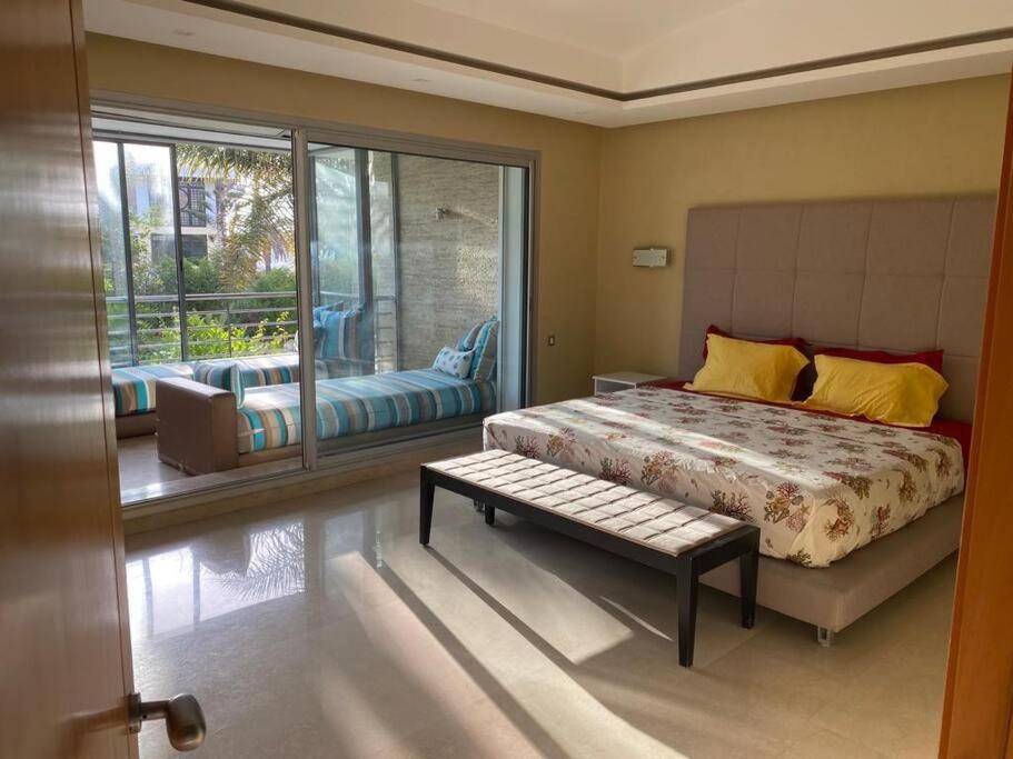 Belle Villa à Bouznika plage - Golf Bouzbay في بوزنيقة: غرفة نوم بسرير ونافذة كبيرة