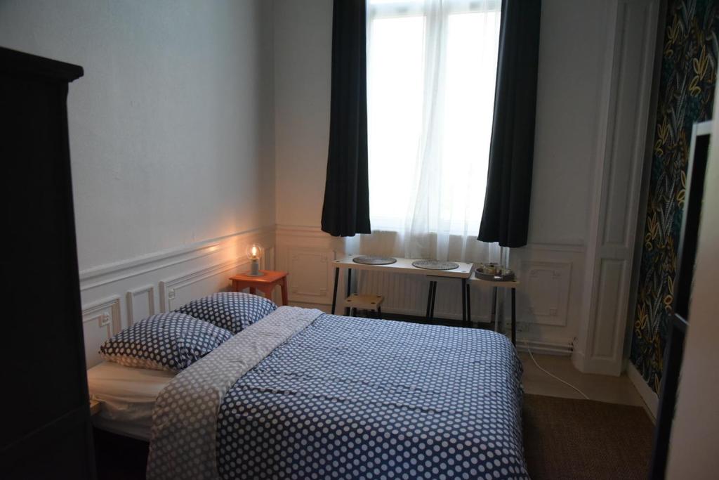 Le Piercot في لييج: غرفة نوم بسرير ونافذة