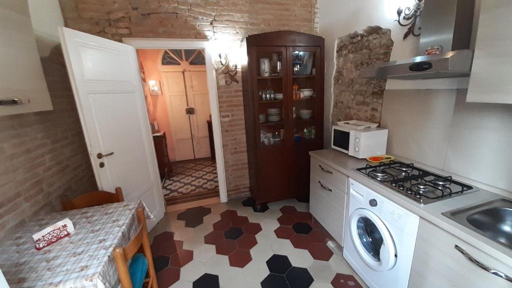 eine kleine Küche mit einem Herd und einer Mikrowelle in der Unterkunft Apartment Cecina in Cecina