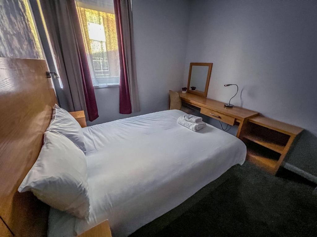 a bedroom with a bed and a table and a mirror at County Hall Apartment Hotel in Boston