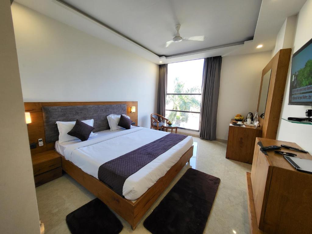 1 dormitorio con cama, escritorio y ventana en Sukoon Signature, en Indore