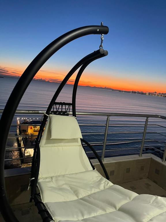 a chair on a boat with a view of the ocean at LuxurySeaview Apartment in Durrës