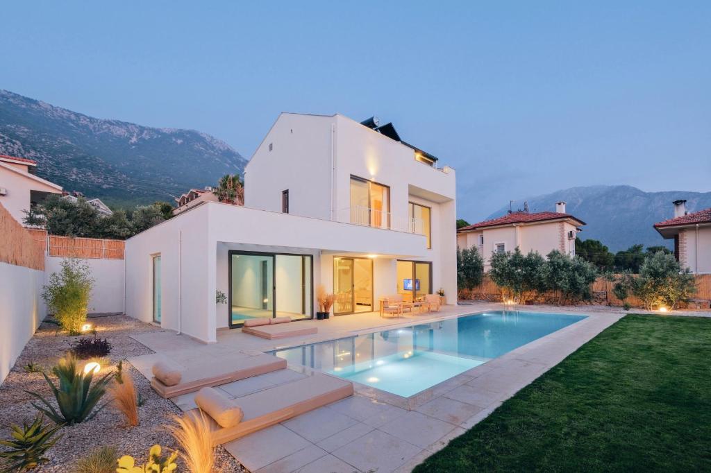 a house with a swimming pool in the yard at Villa Neo with Jakuzi,indoor pool,sauna and floor heating in Fethiye