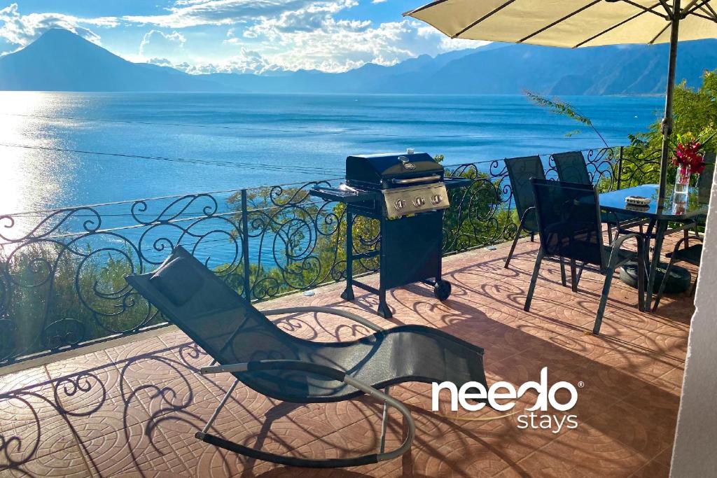 a patio with a grill and chairs and the ocean at Villa Palopo in Santa Catarina Palopó