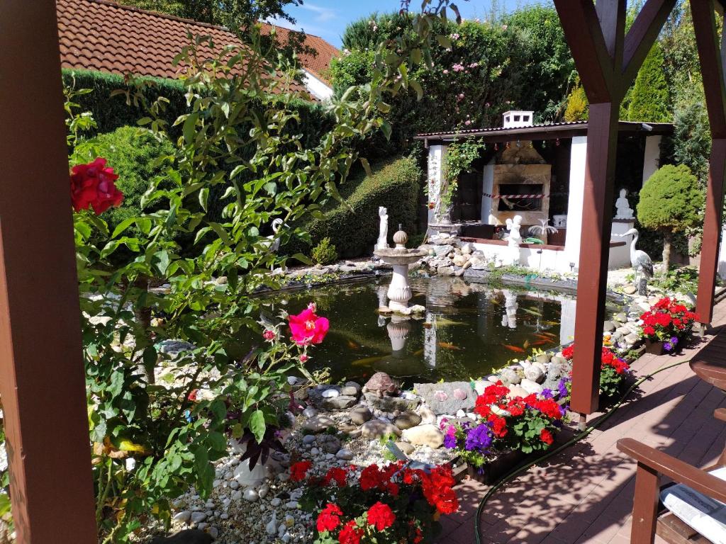 un jardín con un estanque con flores y una fuente en Apartment am Teich en Öhringen
