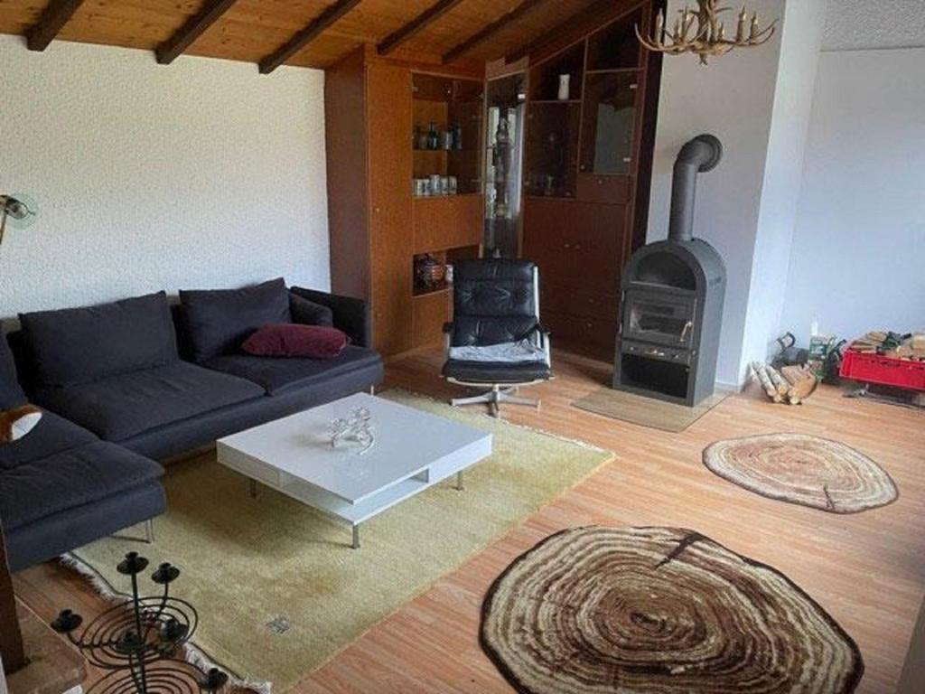 sala de estar con sofá y estufa de leña en Ferienwohnung "do is schee", en Blaibach