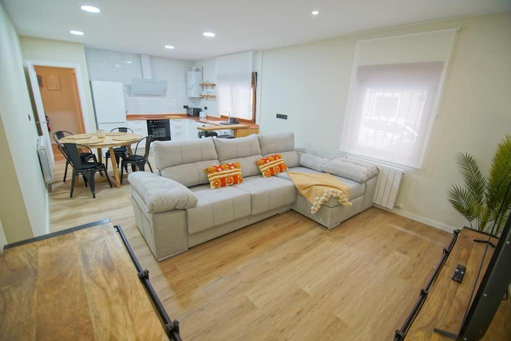 ein Wohnzimmer mit einem Sofa und einem Tisch in der Unterkunft Apartamentos 2K - Apartamento en muelle Olabeaga in Bilbao