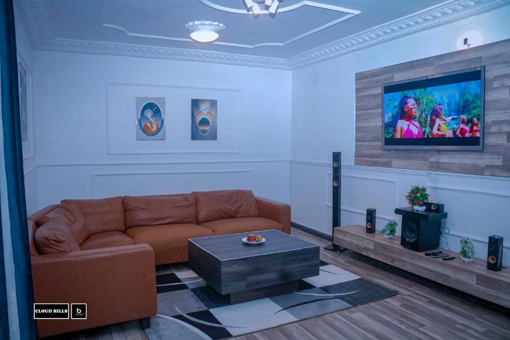 sala de estar con sofá y TV en Cloud Hill, en Buea