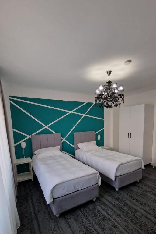 Duas camas num quarto com uma parede verde em BTP House em Hunedoara