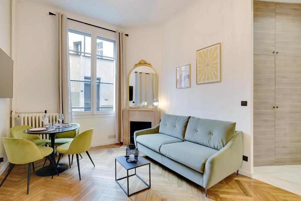uma sala de estar com um sofá e uma mesa em Charming apartment in heart of Le Marais - GetHosted em Paris