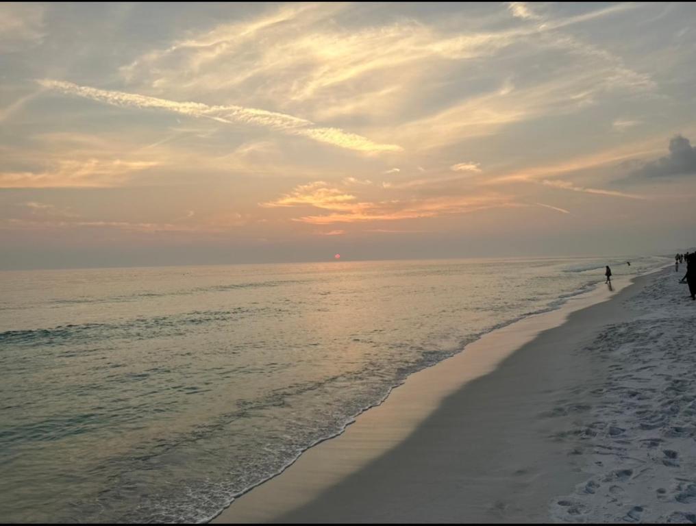 a group of people walking on the beach at Sunset Haven in Destin