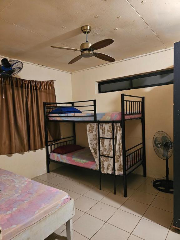 two bunk beds in a room with a ceiling fan at Raihei Auberge de jeunesse Chez l'habitant à Bora Bora in Bora Bora