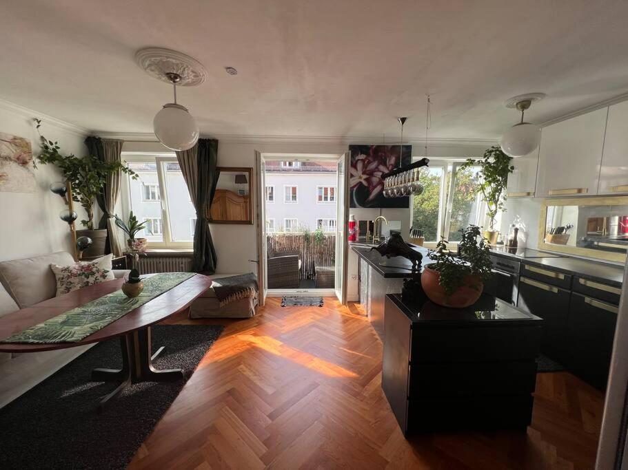een woonkamer met een bank en een tafel bij Bestlage Schwabing Ganze Wohnung in München