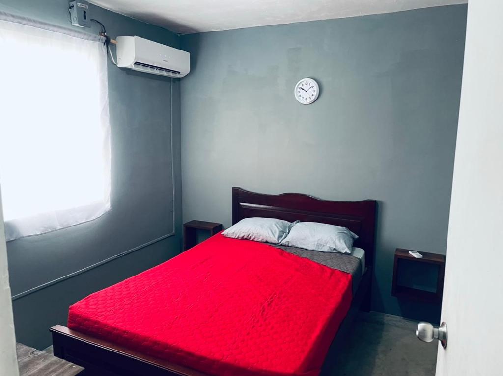 una camera con letto rosso e orologio a parete di Renta por mes Departamentos en Altamira Tamaulipas 