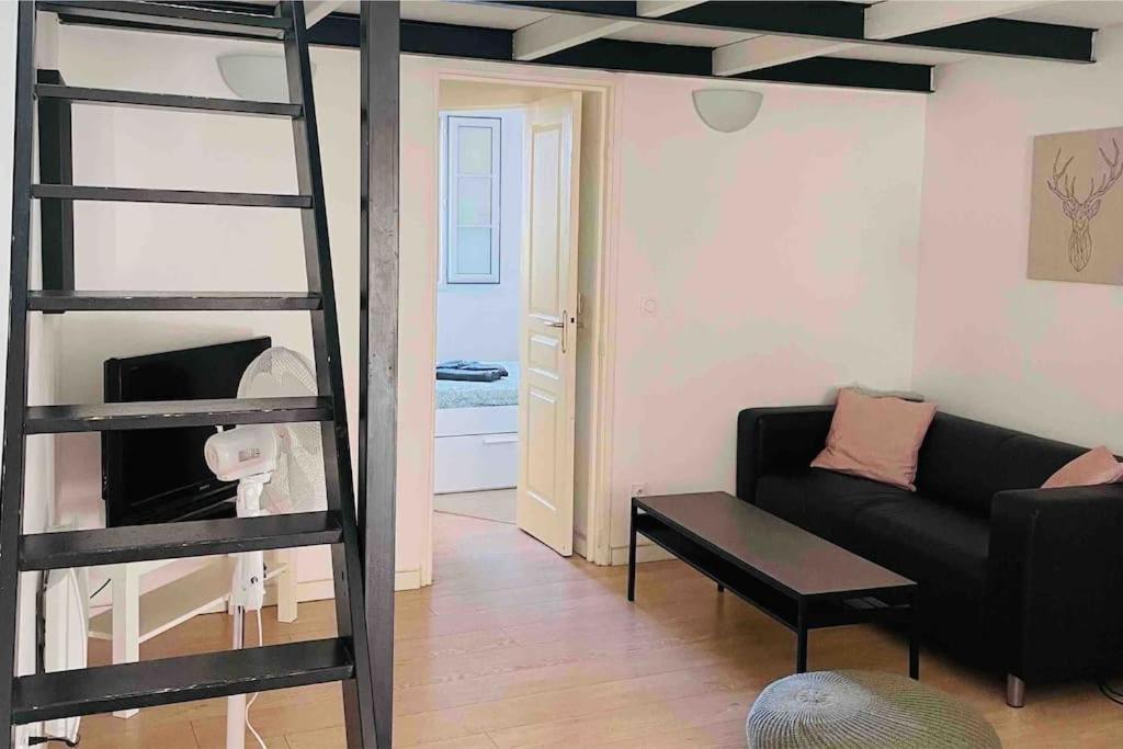 sala de estar con sofá negro y escalera en Appartement cosy au cœur de l’Écusson, en Montpellier